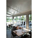 Restaurant interior with tables, chairs, and track lighting; view of outdoor seating and lake.