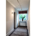 Hallway with white textured wallpaper, track lighting, and gray patterned carpet.