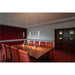 Track lighting with three cylindrical pendant lights, cream finish, suspended over a wood conference table.