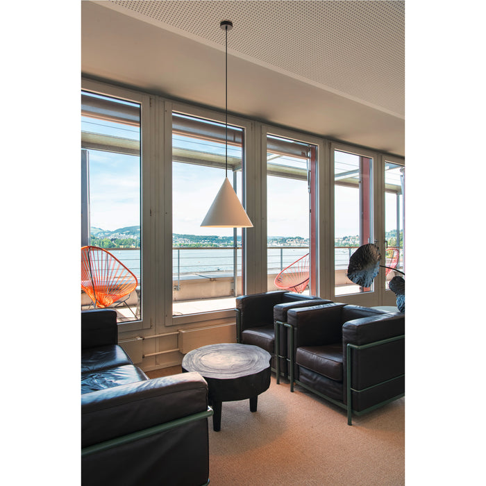 White cone pendant light, ceiling mounted, in a room with black leather chairs and a wood stump table.