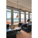 White cone pendant light, ceiling mounted, in a room with black leather chairs and a wood stump table.