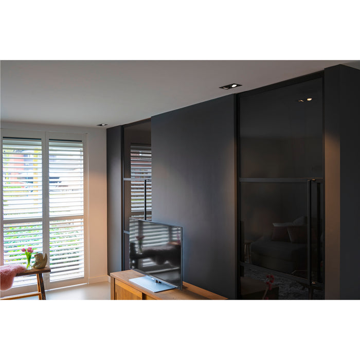 Modern living room with dark gray walls, black glass sliding doors, and wooden TV stand.