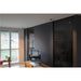Modern living room with dark gray walls, black glass sliding doors, and wooden TV stand.