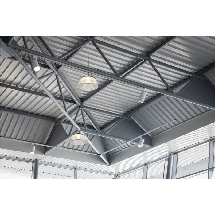 Industrial ceiling with gray metal beams, corrugated metal panels, clear glass pendant lights, and white track lighting.