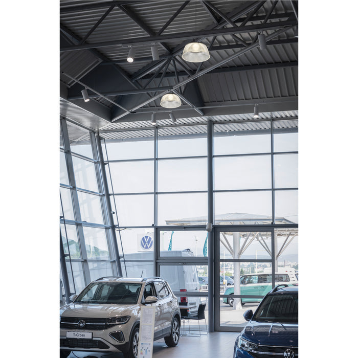 Clear acrylic pendant lights, ceiling mounted, in a car dealership showroom.