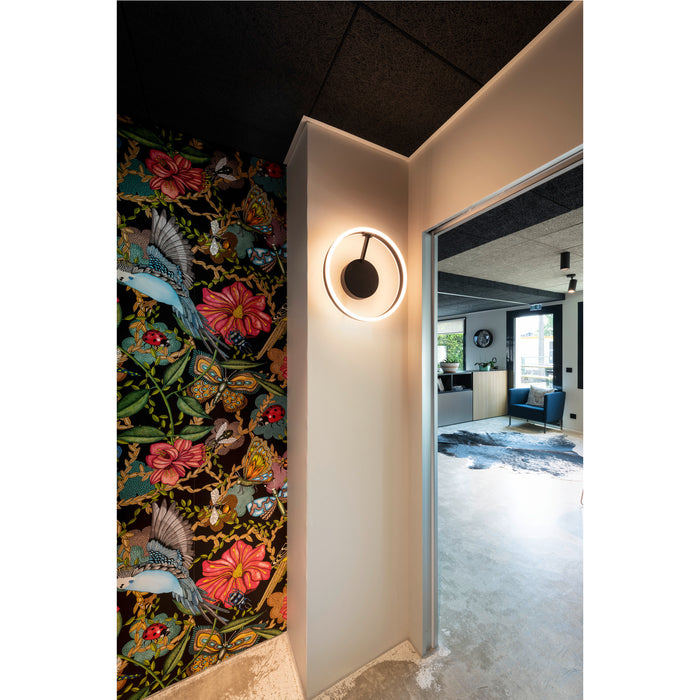 Interior with floral wallpaper, black ceiling tiles, and a round black and white LED wall sconce.