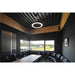 Black ring LED pendant light fixture, suspended from a black metal ceiling in a meeting room.