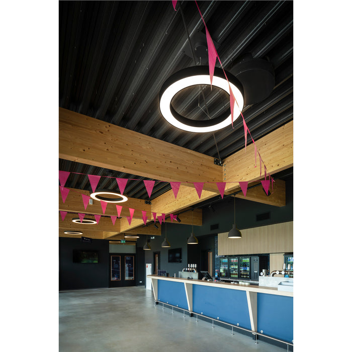 Interior view with black ceiling, wood beams, ring lights, and blue bar.