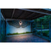 Wall-mounted metal angel wings art, gray finish, illuminated by a sconce.