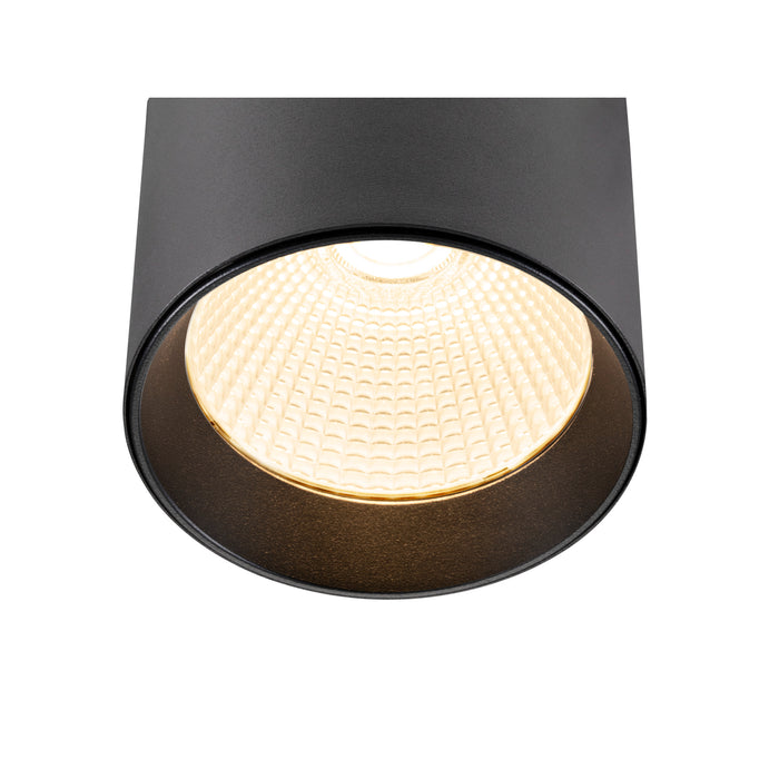 Black cylinder surface-mounted light fixture with textured lens.