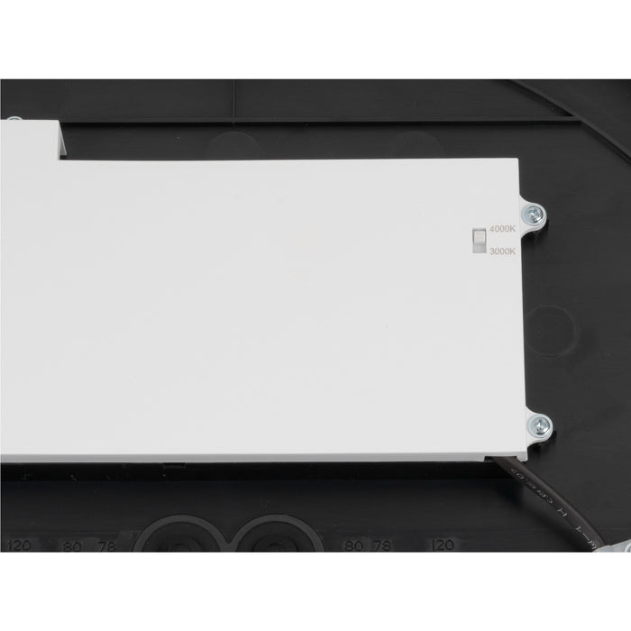Close-up of a black and white light fixture showing the color temperature switch.