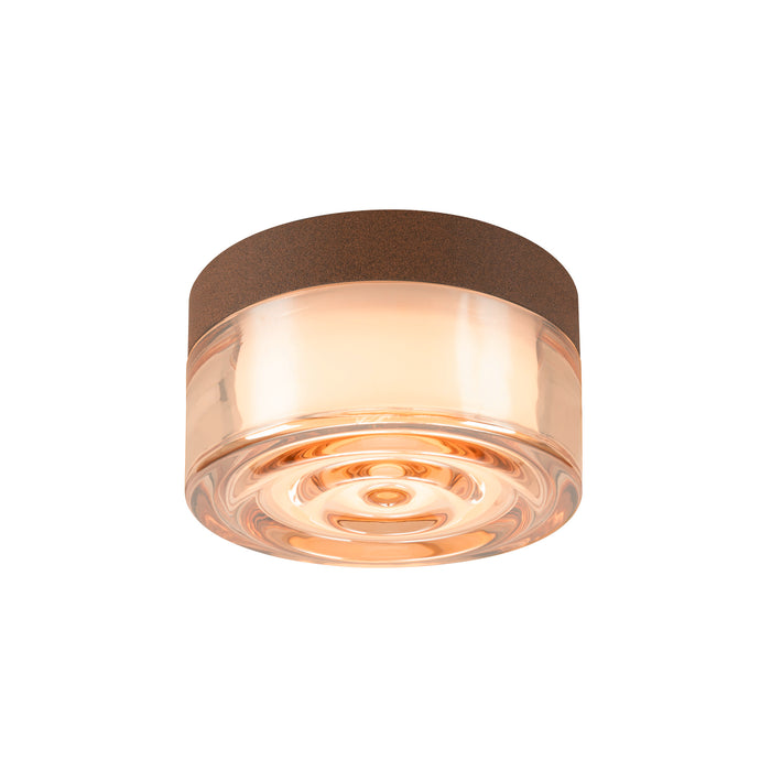 Glass flush mount ceiling light with brown cork trim and amber hue.