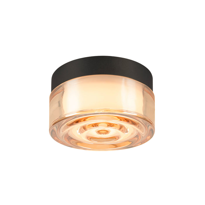 Flush mount ceiling light with amber glass shade and black metal trim.
