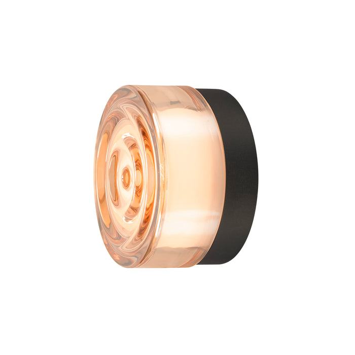 Glass wall sconce with a black mount, peach-toned.