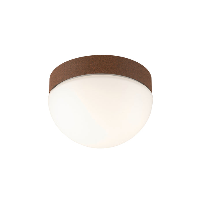Flush mount ceiling light with a cork shade in brown and a white glass diffuser.
