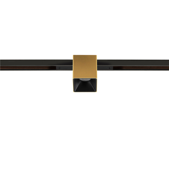 Gold finish square track lighting fixture mounted on black track.