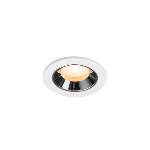 Recessed ceiling light fixture made of metal with a chrome finish and white trim, featuring a warm white LED bulb.