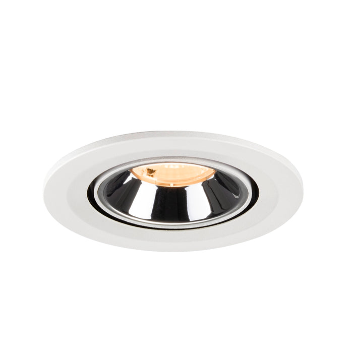 Recessed ceiling light fixture made of metal with a chrome finish and white trim, featuring a warm LED bulb for ambient lighting.