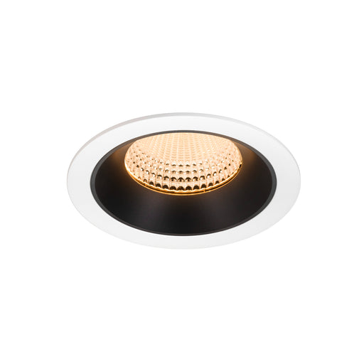 Recessed ceiling light fixture with a white and black finish, made of metal, featuring a textured glass lens and warm LED illumination.