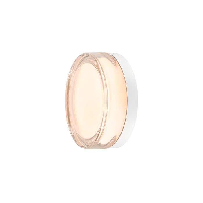 Clear glass jar with white lid, filled with light peach-colored cream.