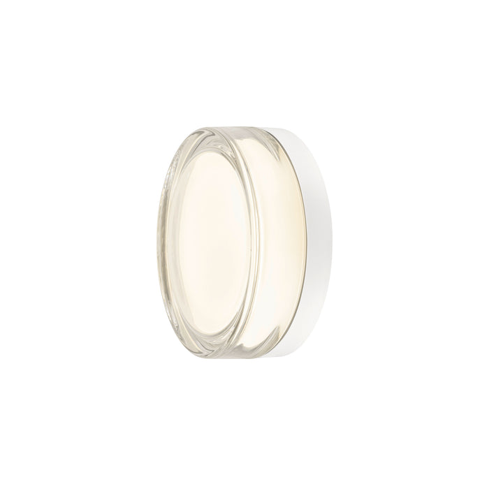 Clear glass wall sconce with white backplate.