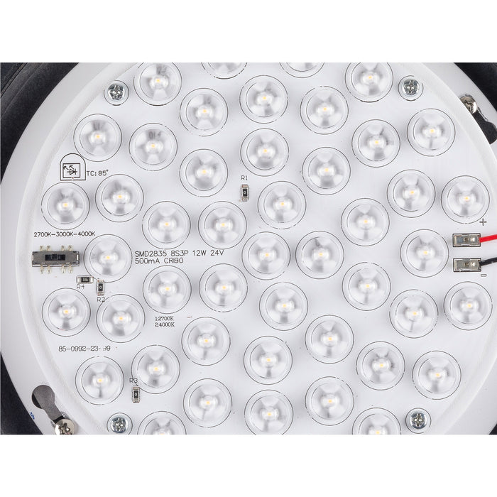 Close-up of a white, round LED light panel with multiple LEDs, visible circuitry, and screw mounting points.