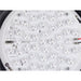 Close-up of a white, round LED light panel with multiple LEDs, visible circuitry, and screw mounting points.