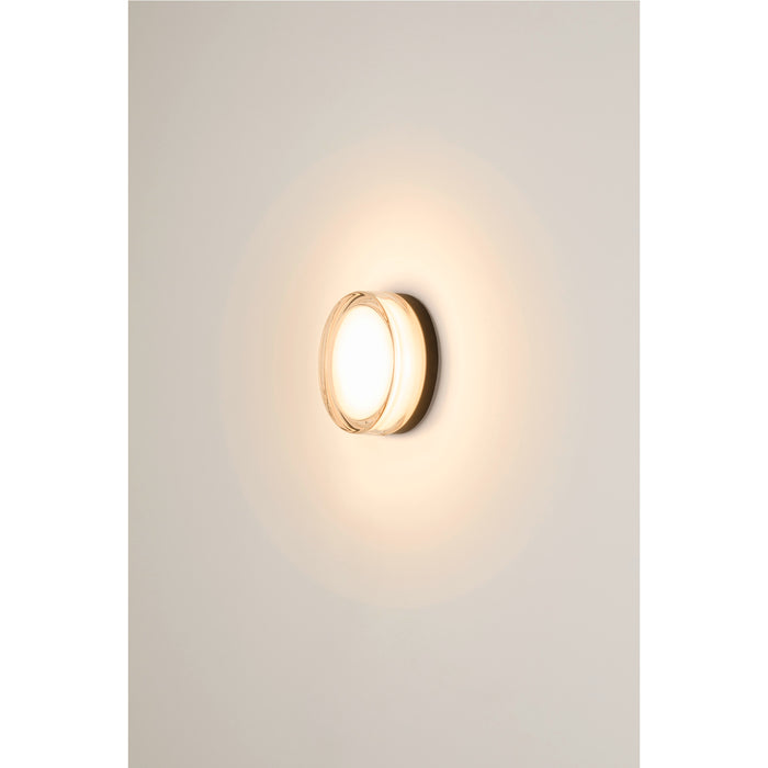 Round glass wall sconce with a bronze finish.
