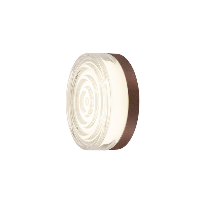 Round glass wall sconce with textured pattern and bronze finish.