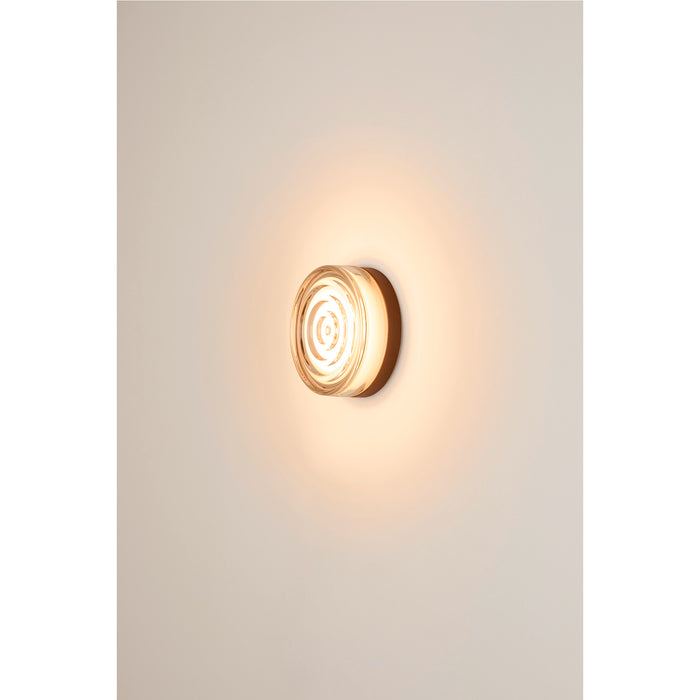 Clear glass wall sconce with concentric circle design and bronze-tone mounting.