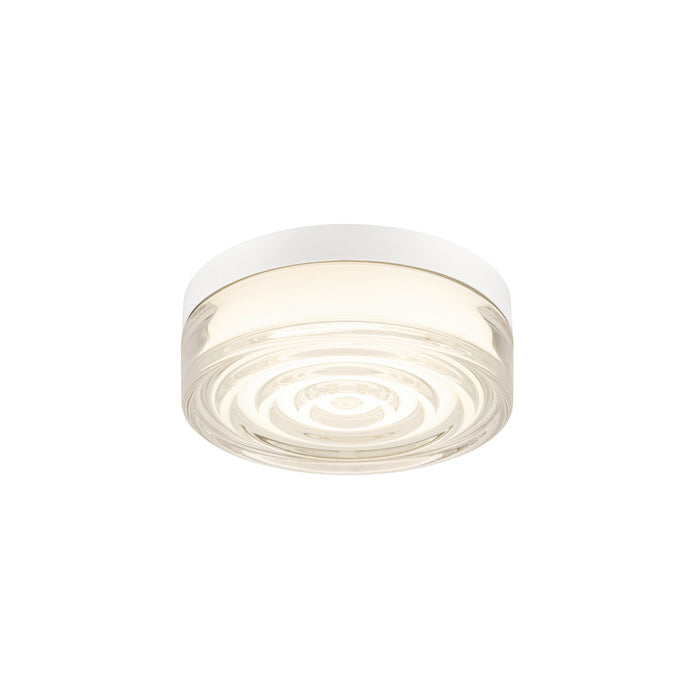 White flush mount ceiling light fixture with clear textured glass.