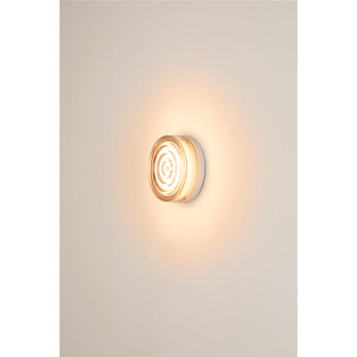Clear glass wall sconce with white mounting.