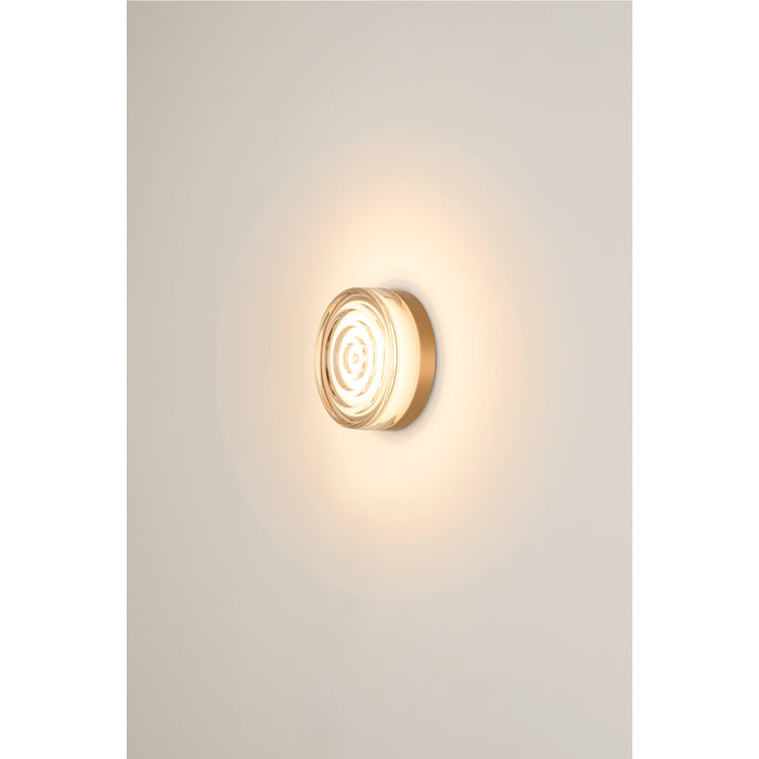Round glass wall sconce with a gold finish.