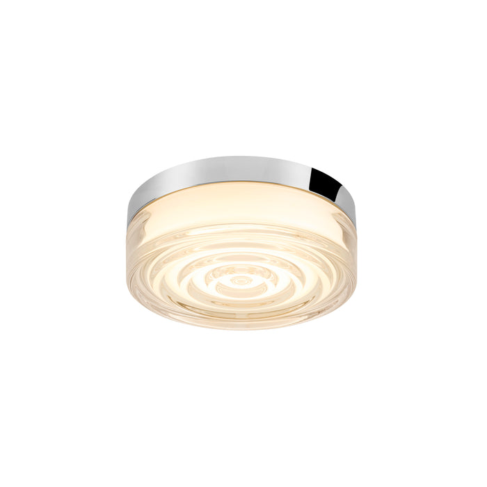 Flush mount ceiling light fixture with clear glass shade, concentric circle pattern, and polished chrome trim.