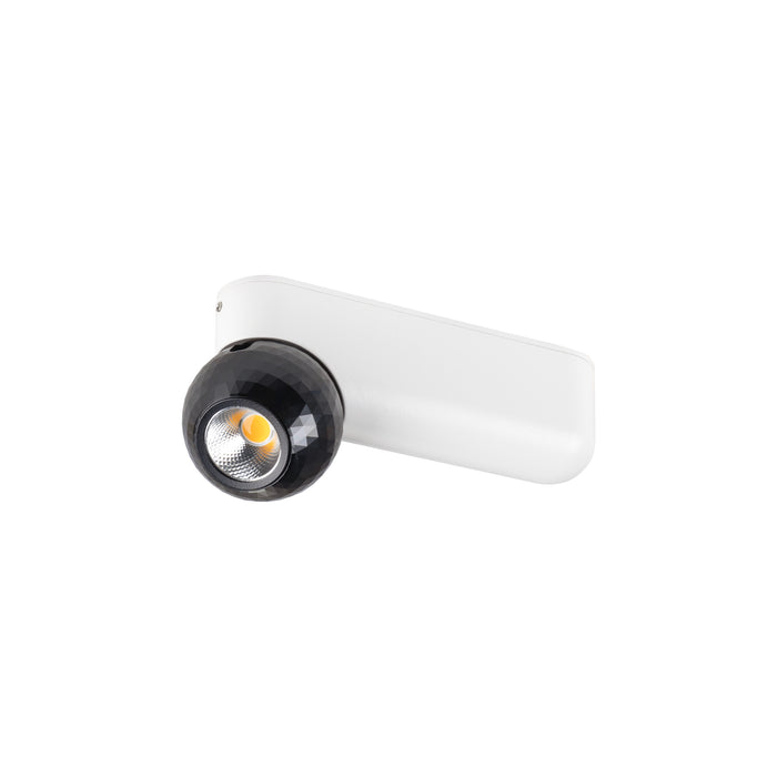 Wall-mounted spotlight with black faceted shade and white base.