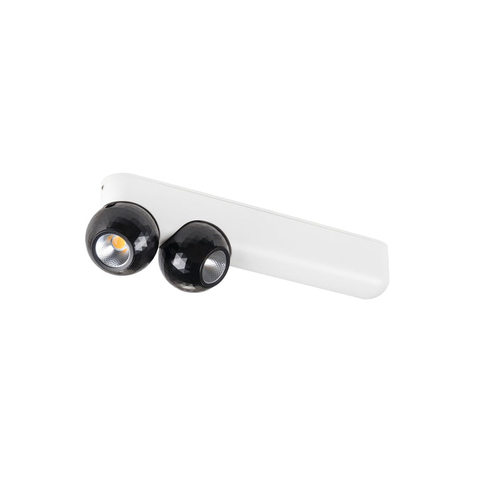 White track light fixture with two black faceted globe spotlights, surface mounted.