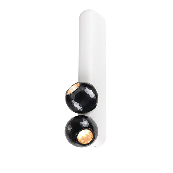 Modern wall-mounted light fixture with two black faceted shades and a white backplate.