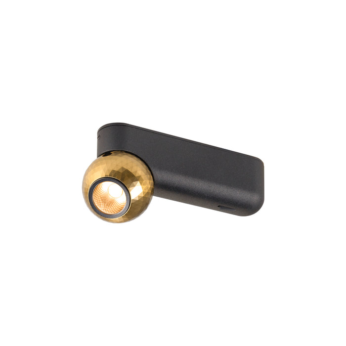 Wall-mounted spotlight with textured gold sphere and matte black rectangular base.