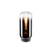 Glass table lamp with black base and exposed filament bulb.