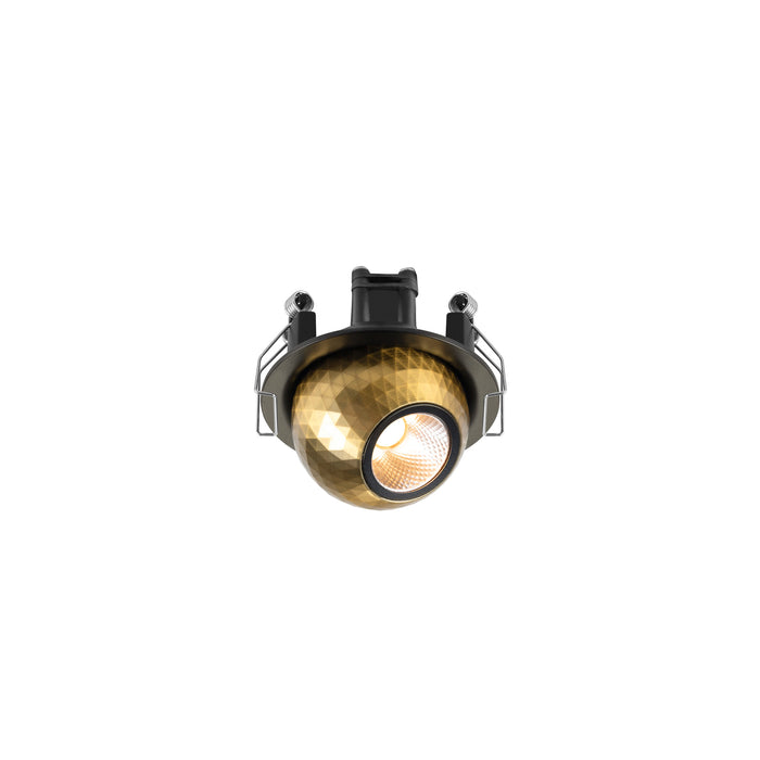 Brass recessed spotlight with geometric pattern and black mounting hardware.