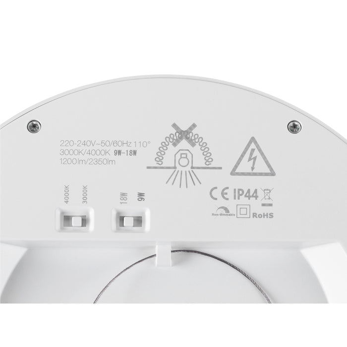 Close-up of a white light fixture showing voltage, wattage, and color temperature settings.
