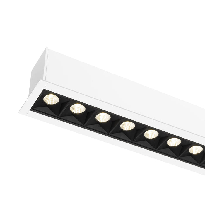 Recessed linear LED light fixture, white finish, with black baffle.
