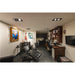 Tattoo studio interior with black leather chairs, dark wood desk and cabinets, and artwork.