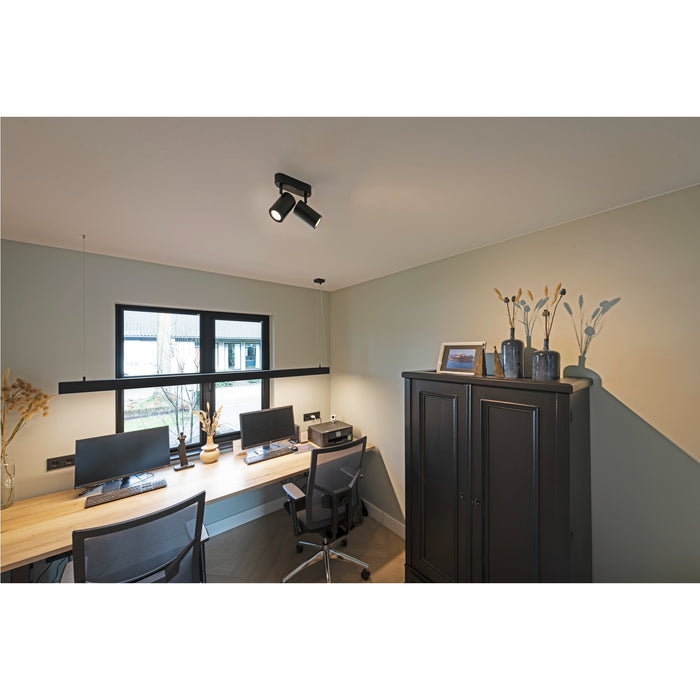 Modern home office with black track lighting, wood desk, and black cabinet.