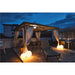 Outdoor rooftop patio with metal gazebo, white curtains, lounge chair, and round floor lamps.