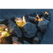 Outdoor landscape lighting illuminating gray granite rocks in a garden bed.